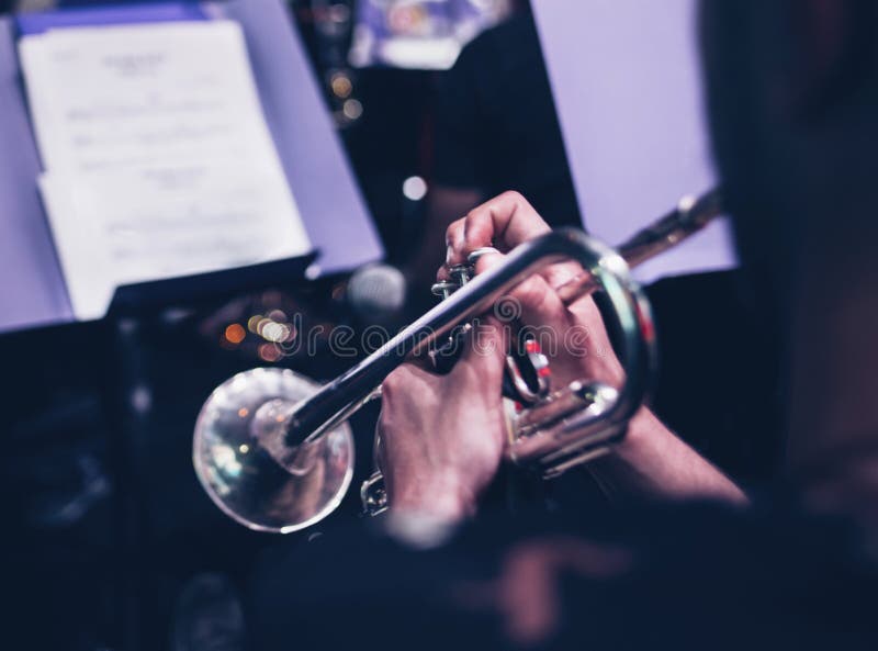 Fondo di musica di concerto del primo piano del giocatore di tromba fotografia stock Fondo di musica di concerto del primo piano del giocatore di tromba fotografia stock