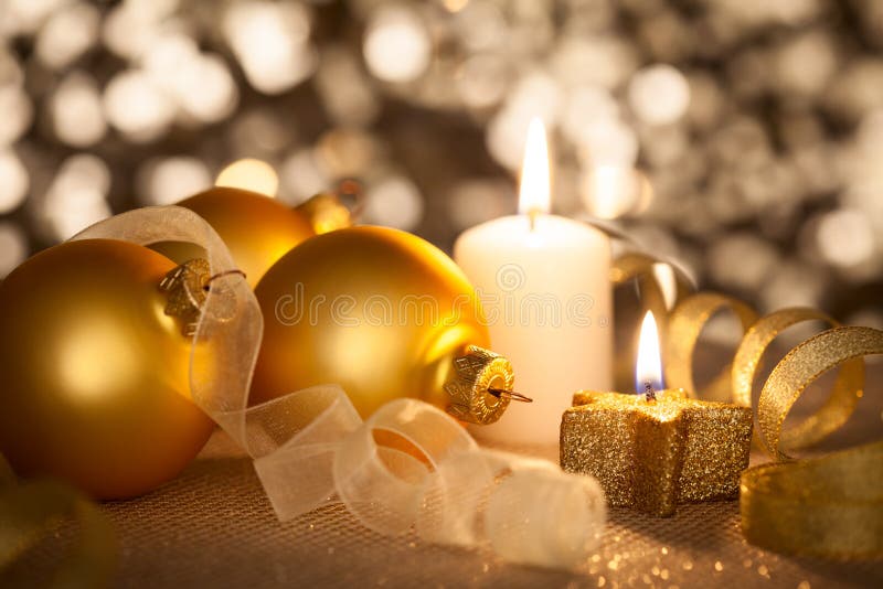 Fondo dorato di Natale con le candele, le bagattelle ed i nastri fotografia stock libera da diritti Fondo dorato di Natale con le candele, le bagattelle ed i nastri fotografia stock libera da diritti