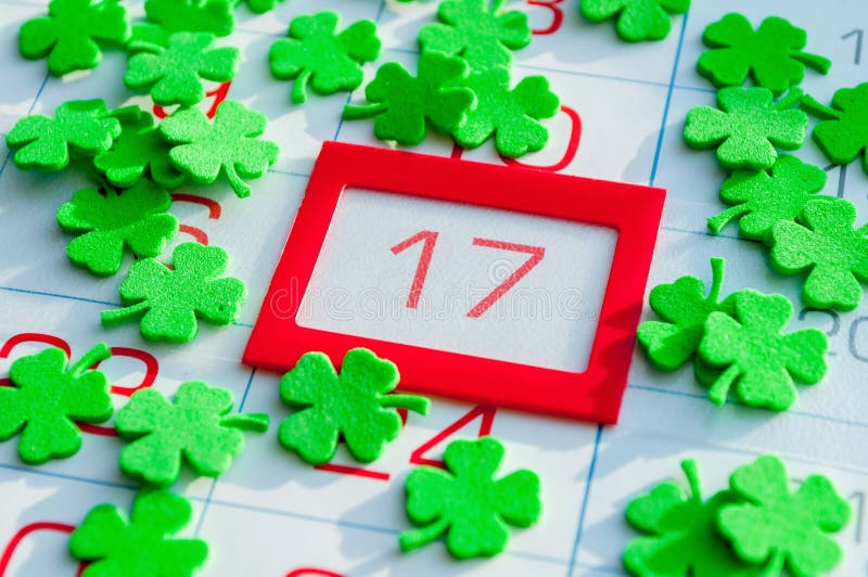 Fondo festivo del día del ` s de St Patrick Quatrefoils verdes que cubren el calendario con el 17 de marzo enmarcado rojo brillan fotos de archivo libres de regalías Fondo festivo del día del ` s de St Patrick Quatrefoils verdes que cubren el calendario con el 17 de marzo enmarcado rojo brillan fotos de archivo libres de regalías