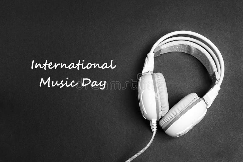Fondo internacional del día de la música con los auriculares blancos en blac fotos de archivo Fondo internacional del día de la música con los auriculares blancos en blac fotos de archivo