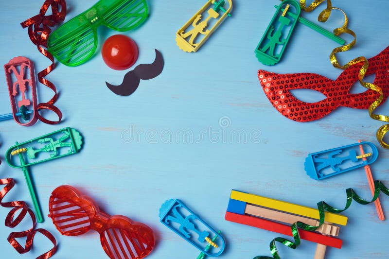 Fondo judío del purim del día de fiesta con la máscara del carnaval, el traje del partido y el noisemaker imagen de archivo Fondo judío del purim del día de fiesta con la máscara del carnaval, el traje del partido y el noisemaker imagen de archivo