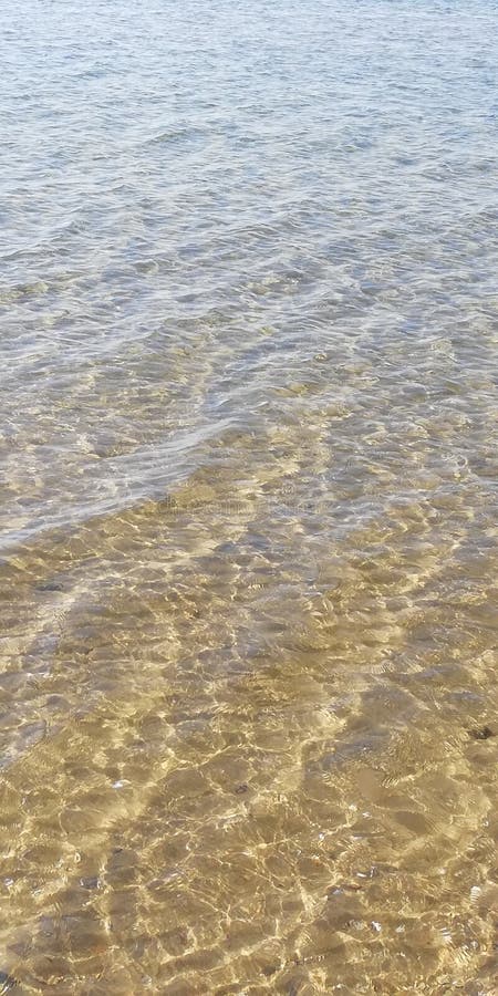 Fondo L'abbagliamento del sole sull'acqua di mare Il fondo del mare attraverso le onde un giorno soleggiato di estate immagini stock libere da diritti Fondo L'abbagliamento del sole sull'acqua di mare Il fondo del mare attraverso le onde un giorno soleggiato di estate immagini stock libere da diritti