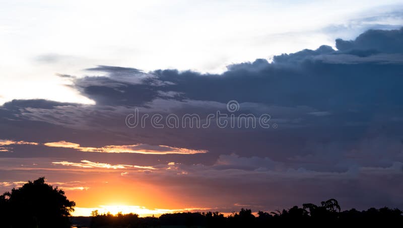 Fondo oscuro de cielo nublado sobre la puesta del sol en el cielo de la tarde en el campo de Tailandia foto de archivo libre de regalías Fondo oscuro de cielo nublado sobre la puesta del sol en el cielo de la tarde en el campo de Tailandia foto de archivo libre de regalías