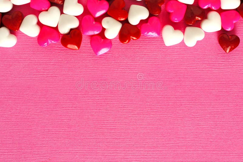Fondo rosado del día de tarjetas del día de San Valentín con la frontera del caramelo foto de archivo libre de regalías Fondo rosado del día de tarjetas del día de San Valentín con la frontera del caramelo foto de archivo libre de regalías