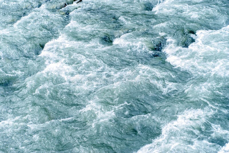 fondo, textura: una corriente rápida del agua en un río de la montaña imagen de archivo libre de regalías fondo, textura: una corriente rápida del agua en un río de la montaña imagen de archivo libre de regalías