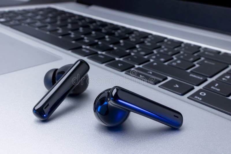 Fones de ouvido sem fio pretos sobre laptop fotografia de stock royalty free