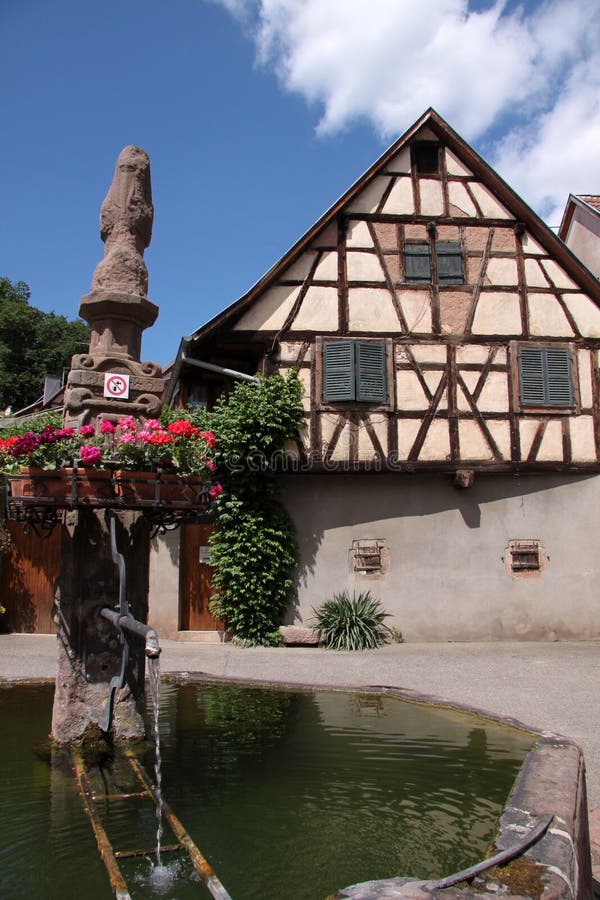 Fontana del villaggio con con la casa half-timbered fotografie stock Fontana del villaggio con con la casa half-timbered fotografie stock