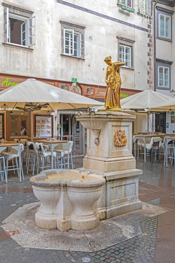 Ljubljana, Slovenia - November 4, 2019: Golden Water Fountain Landmark at Ribji Square in Capital City Rainy Fall Day. Ljubljana, Slovenia - November 4, 2019: Golden Water Fountain Landmark at Ribji Square in Capital City Rainy Fall Day