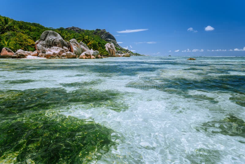 Anse Source d`Argent - Paradise tropical beach. Shallow lagoon on low tide, Granite boulders and palm trees. La Digue island, Seychelles. Anse Source d`Argent - Paradise tropical beach. Shallow lagoon on low tide, Granite boulders and palm trees. La Digue island, Seychelles.