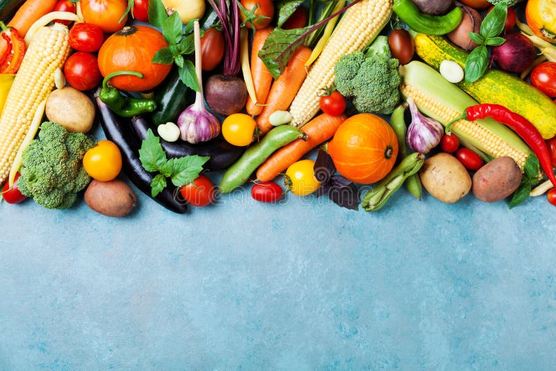 Food background with autumn farm vegetables and root on blue table top view. Healthy and organic harvest.