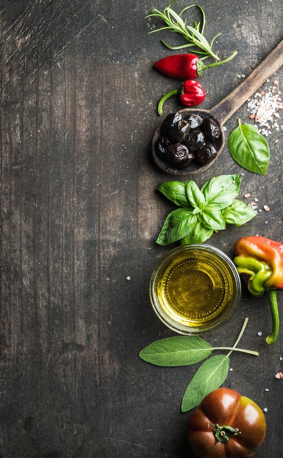 Food background with vegetables, herbs and condiment. Greek black olives, fresh basil, sage, rosemary, tomato, peppers