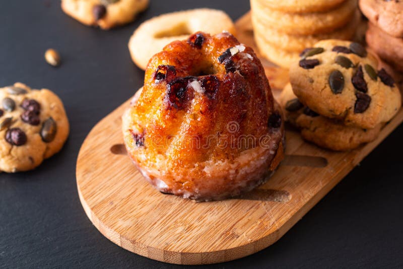 Food Breakfast or snack concept european Gugelhupf, Kougelhopf, kouglof yeast Bundt ring cake with cookies on black background.