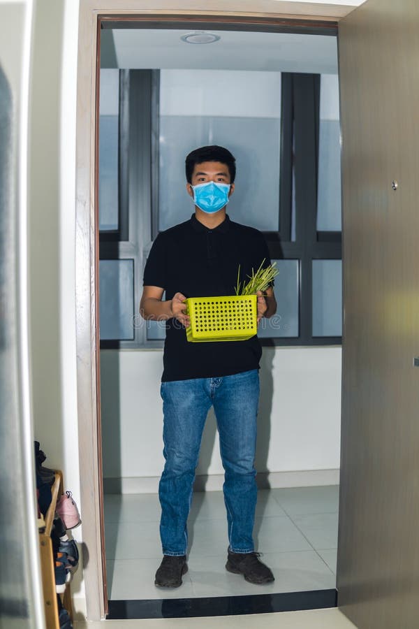 Food delivery during corona virus outbreak. Asian Young delivery man courier delivering grocery order in coronavirus epidemic. Saf royalty free stock photography Food delivery during corona virus outbreak. Asian Young delivery man courier delivering grocery order in coronavirus epidemic. Saf royalty free stock photography