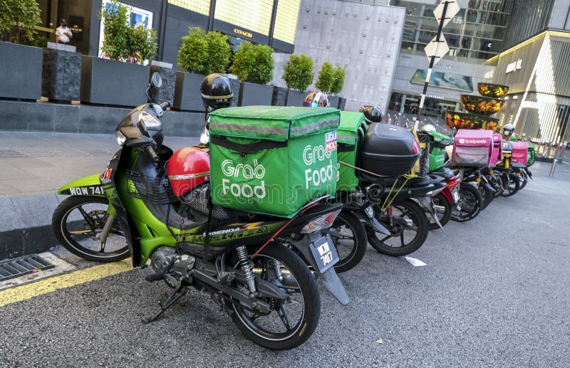 KUALA LUMPUR, MALAYSIA - APRIL 19, 2020: Food delivery service rider for Foodpanda and GrabFood. Food delivery service through its mobile application