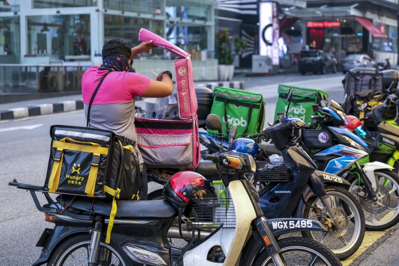 KUALA LUMPUR, MALAYSIA - APRIL 19, 2020: Food delivery service rider for Foodpanda and GrabFood. Food delivery service through its mobile application