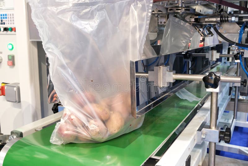Food factory automated robotic machine. Conveyor product line for cooking and packing rations and food packs. packing potatoes in stock photos Food factory automated robotic machine. Conveyor product line for cooking and packing rations and food packs. packing potatoes in stock photos