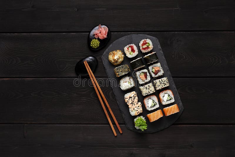 Japanese set, roll philadelphia classic, salmon teriyaki, spicy salmon, yasai maki, on a black plate, top view, horizontal, no peo