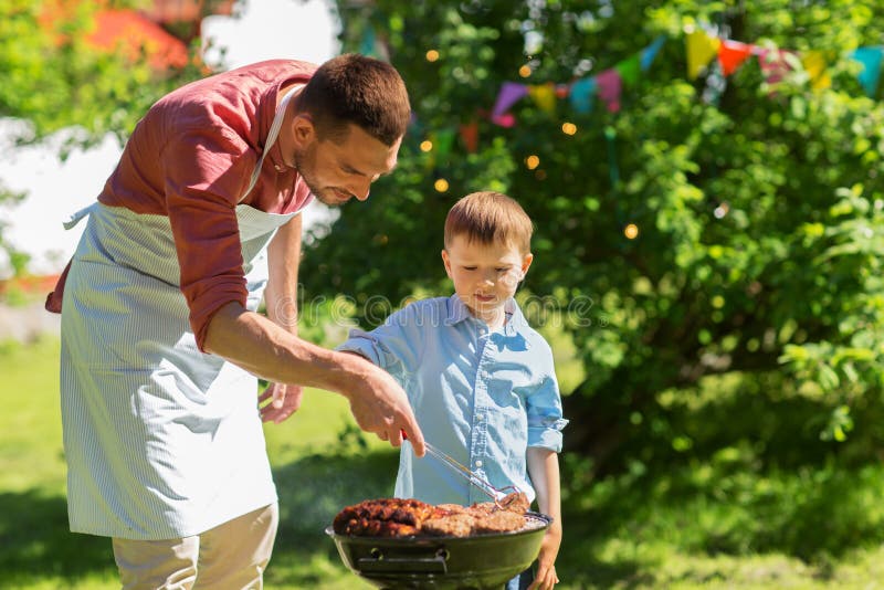 Father and son cooking meat on barbecue grill royalty free stock photography Father and son cooking meat on barbecue grill royalty free stock photography