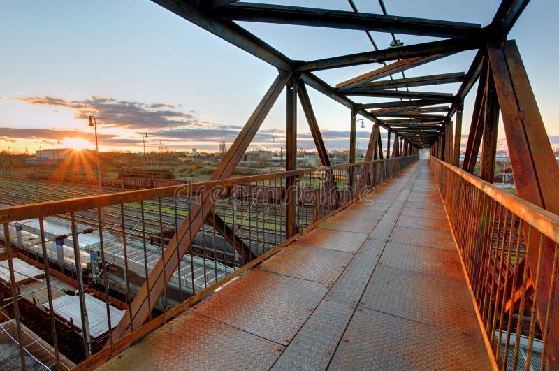 Foot bridge over railway at sunset stock photos