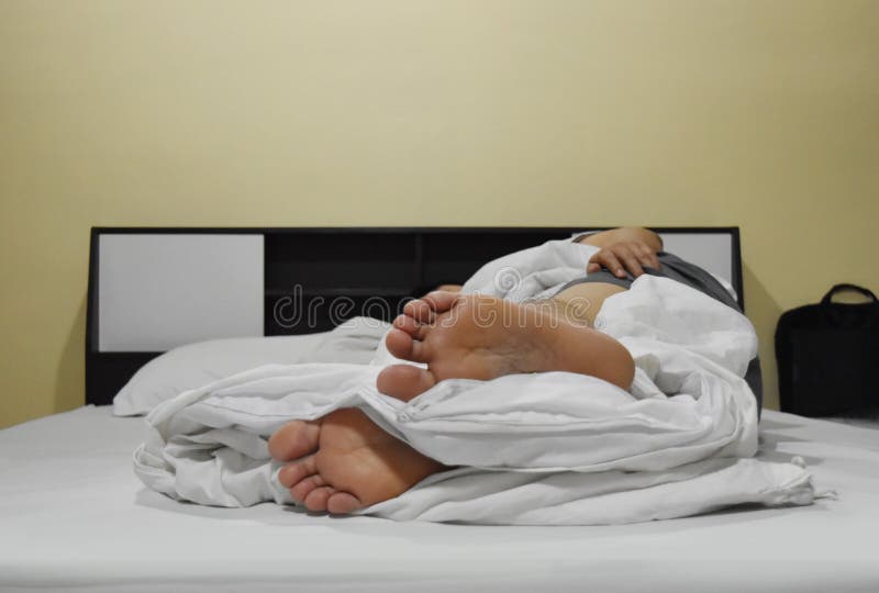 Foot of a young man lying on bed . stock photo Foot of a young man lying on bed . stock photo