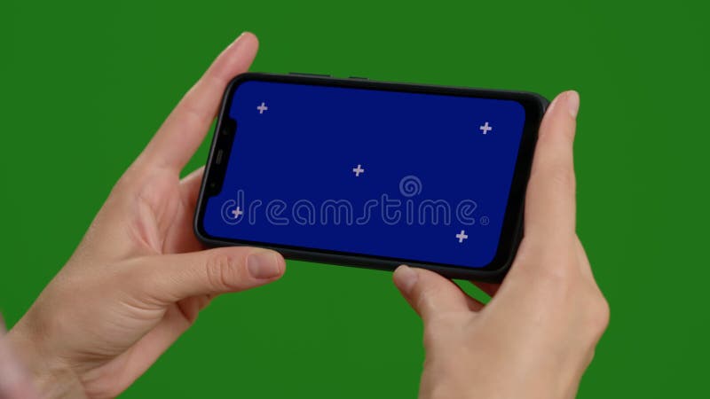 Footage with woman hands holding blue screen phone over green screen background. stock video footage