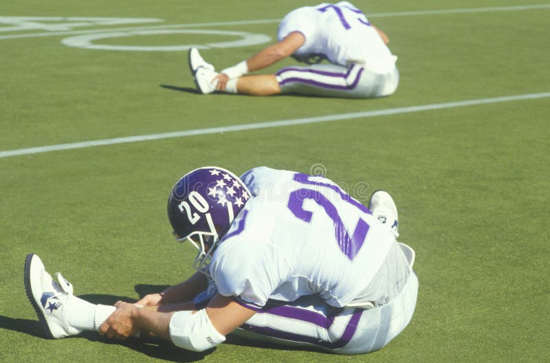 Football Player stretching on field stock photo