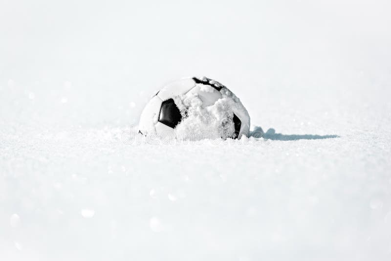 Football or soccer ball in the deep white snow, close season and winter break