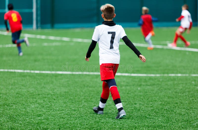 Football teams - boys in red, blue, white uniform play soccer on the green field. boys dribbling. dribbling skills. Team game stock images Football teams - boys in red, blue, white uniform play soccer on the green field. boys dribbling. dribbling skills. Team game stock images