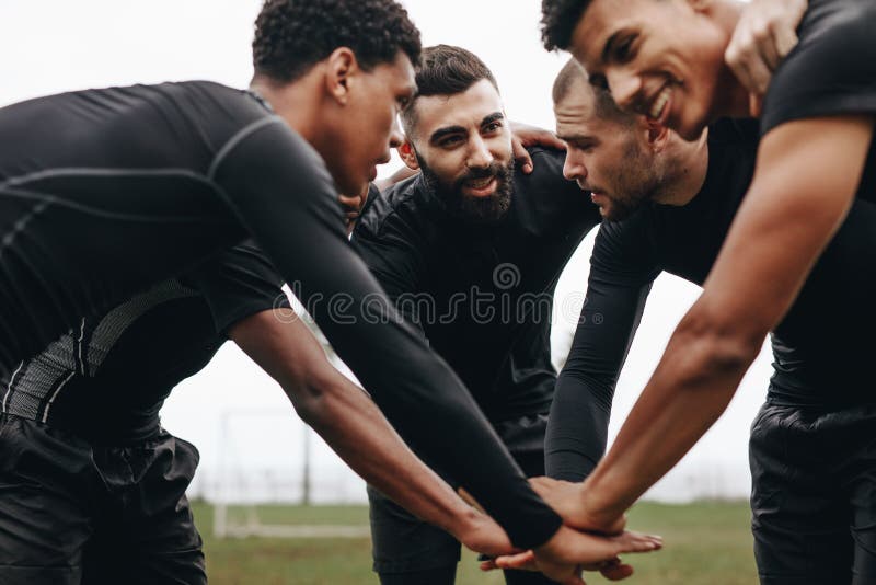Footballeurs joignant des mains dans le petit groupe parlant de la stratégie de jeu Vue d'angle faible des footballers se pliant photos libres de droits Footballeurs joignant des mains dans le petit groupe parlant de la stratégie de jeu Vue d'angle faible des footballers se pliant photos libres de droits