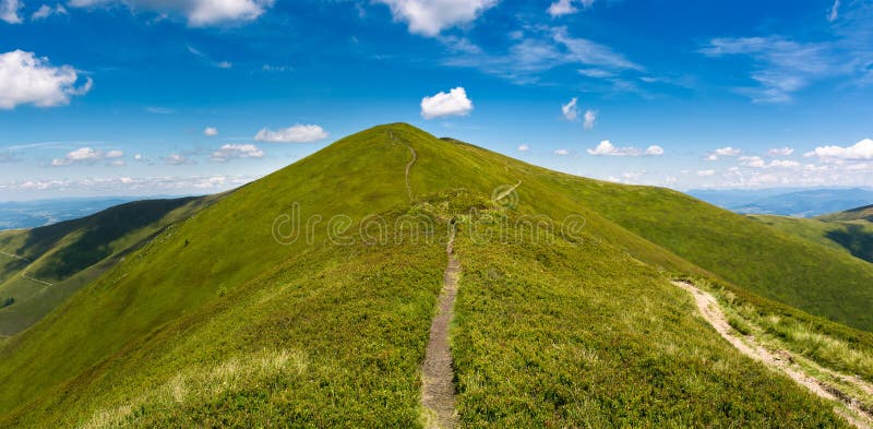 Footpath through grassy peak of mountain ridge