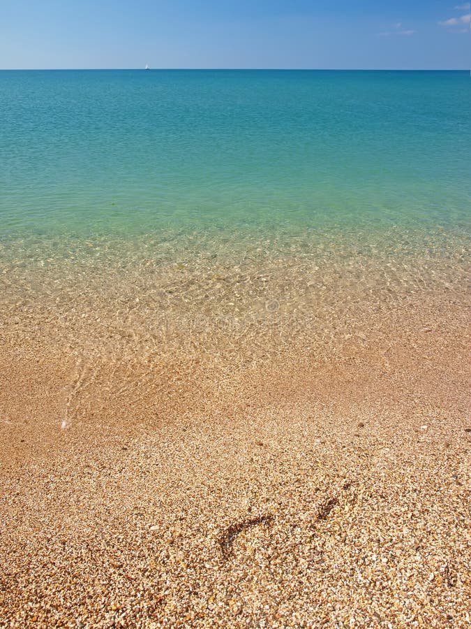 Footprints on the beach and calm sea