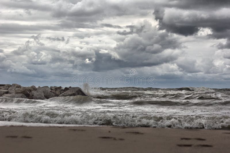 Footprints in the sand and large waves on Lake Michigan