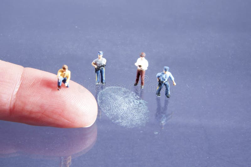 Miniature crime scene investigation team comparing actual finger with a dusted fingerpringt. Miniature crime scene investigation team comparing actual finger with a dusted fingerpringt