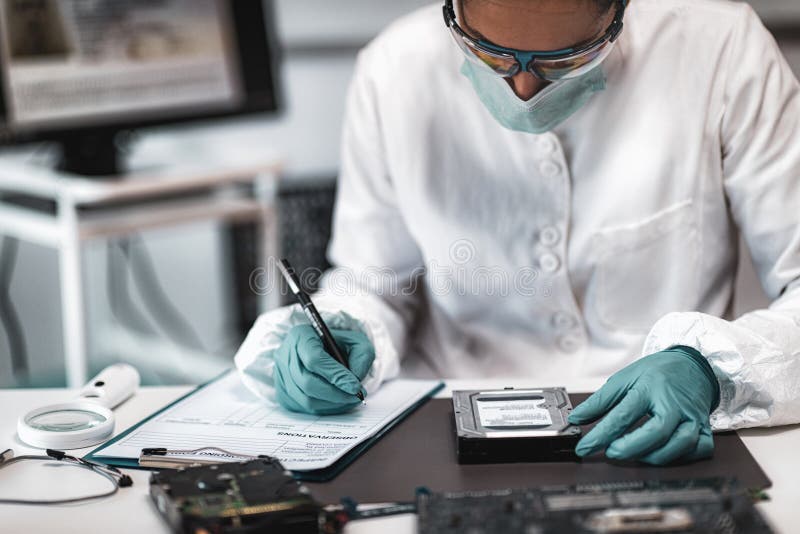 Forensic Science Investigator Examining Computer Hard Drive. Digital Forensic Science Concept. Forensic Science Investigator Examining Computer Hard Drive. Digital Forensic Science Concept