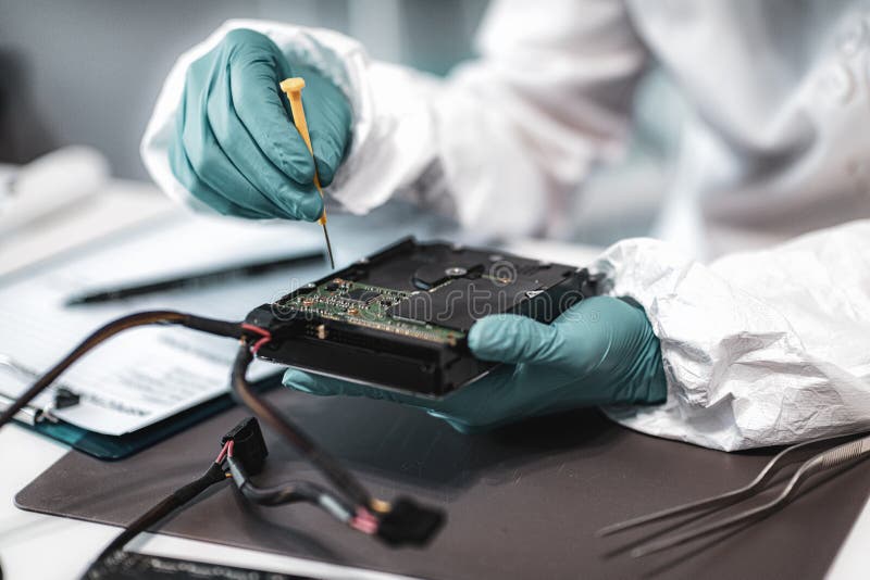 Forensic Science Investigator Examining Computer Hard Drive. Digital Forensic Science Concept. Forensic Science Investigator Examining Computer Hard Drive. Digital Forensic Science Concept