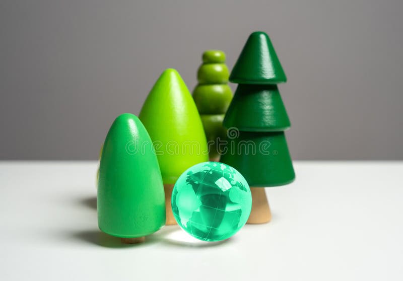 Forest and blue globe. Wooden tree figurines. stock photos