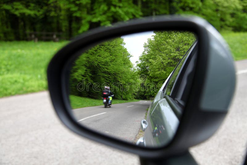 Forest road reflection, rearview car driving mirror view green