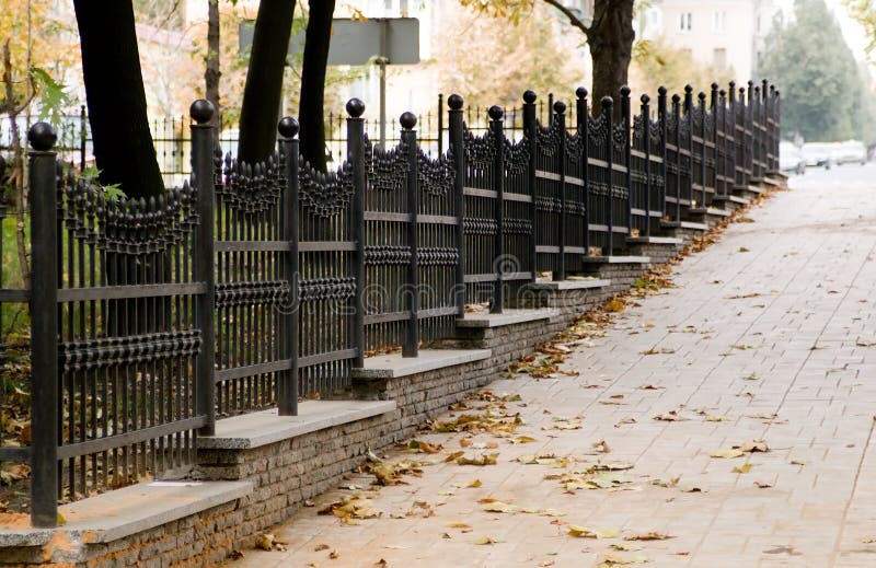 Forged fence in autumn street