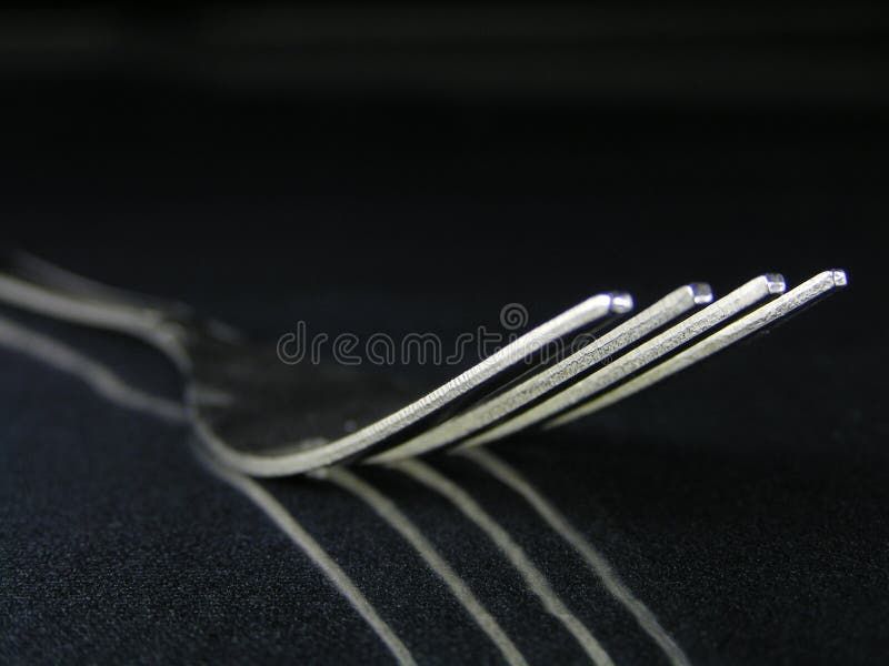 Fork on a isolated reflective black baackground. Restaraunt stock images, royalty-free photos and pictures