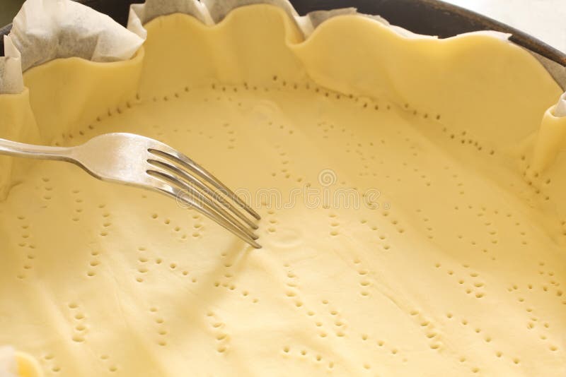 Fork pricking a dought in a baking tin with copy space for your text. Dought stock images, royalty-free photos and pictures
