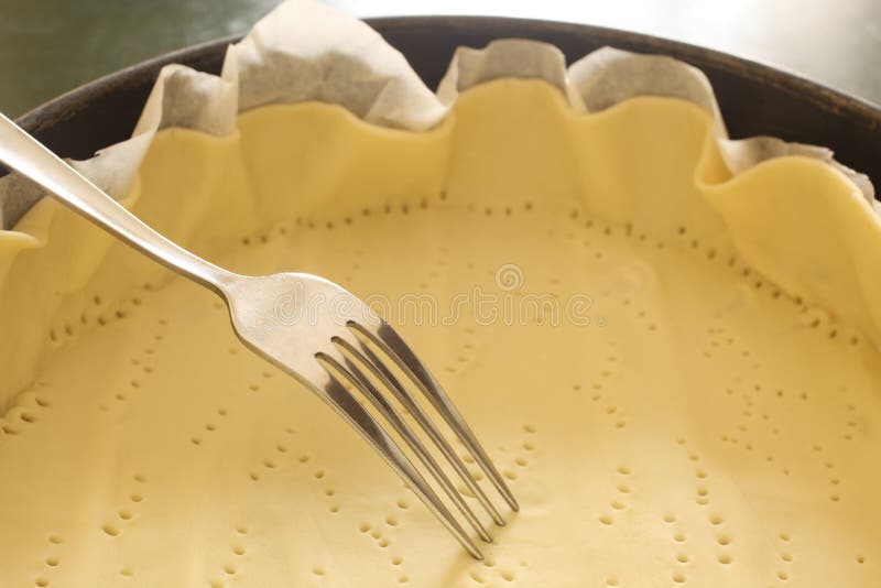 Fork pricking a dought in a baking tin with copy space for your text. Dought stock images, royalty-free photos and pictures