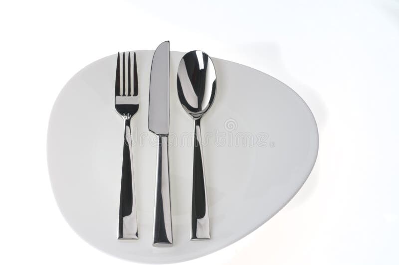 Fork, spoon and knife on a plate over white