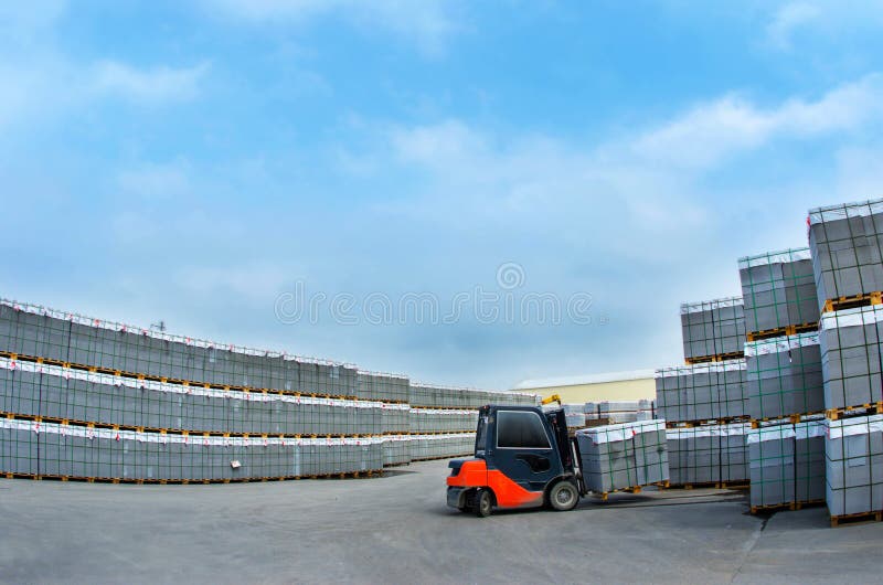 Forklift praca w magazynie dla produkci betonowi bloki zdjęcia stock Forklift praca w magazynie dla produkci betonowi bloki zdjęcia stock