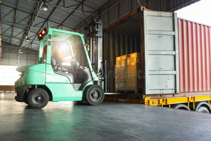 Forklift Tractor Loading Packaging Boxes on Pallets into Shipping