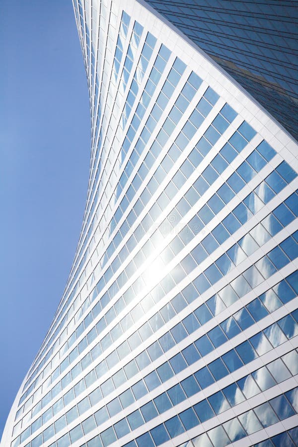 Form för vägg för skyskrapa för exponeringsglasspegel spiral på blå himmel, vit molnbakgrund, modern byggnad för affärsmitt royaltyfri bild Form för vägg för skyskrapa för exponeringsglasspegel spiral på blå himmel, vit molnbakgrund, modern byggnad för affärsmitt royaltyfri bild
