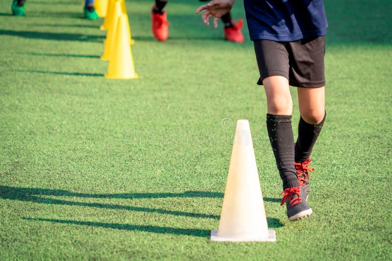 Menino Do Jogador De Futebol Que Pisa Na Bola Na Sala Imagem de