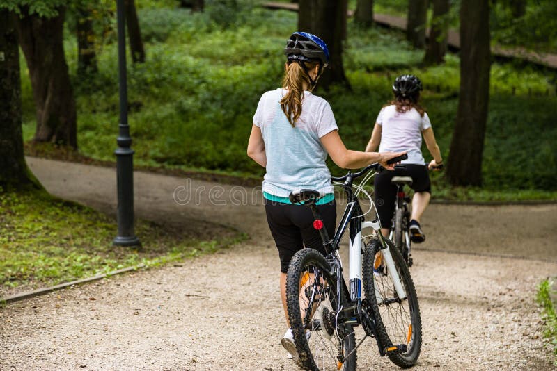 Forma de vida sana - bicicletas que montan de la gente en parque de la ciudad imagen de archivo libre de regalías Forma de vida sana - bicicletas que montan de la gente en parque de la ciudad imagen de archivo libre de regalías