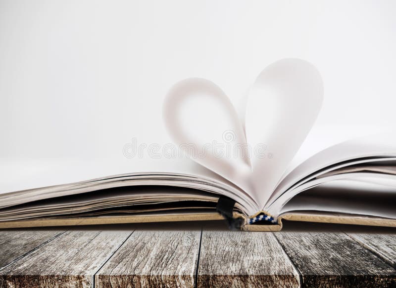 Forma del cuore in pagina aperta del taccuino, sulla tavola di legno fotografie stock libere da diritti