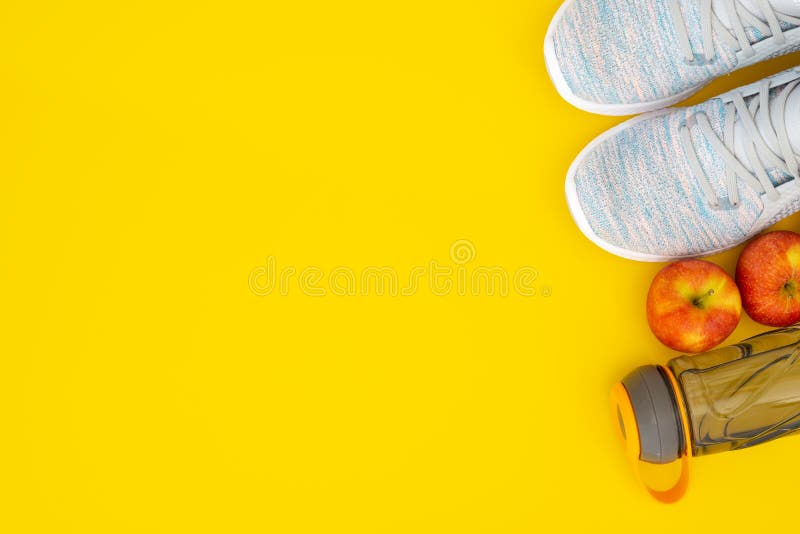 Fitness and healthy active lifestyle background concept.  Training sneakers,  water bottle and apples on yellow background. Top view with space for your advertisement accessories activity athlete body copy design diet dieting drink equipment exercise fashion food footwear freshness fruit gym mineral nutrition running set shoe shoes slim sporting sports sportswear table wellness white wood wooden workout. Fitness and healthy active lifestyle background concept.  Training sneakers,  water bottle and apples on yellow background. Top view with space for your advertisement accessories activity athlete body copy design diet dieting drink equipment exercise fashion food footwear freshness fruit gym mineral nutrition running set shoe shoes slim sporting sports sportswear table wellness white wood wooden workout