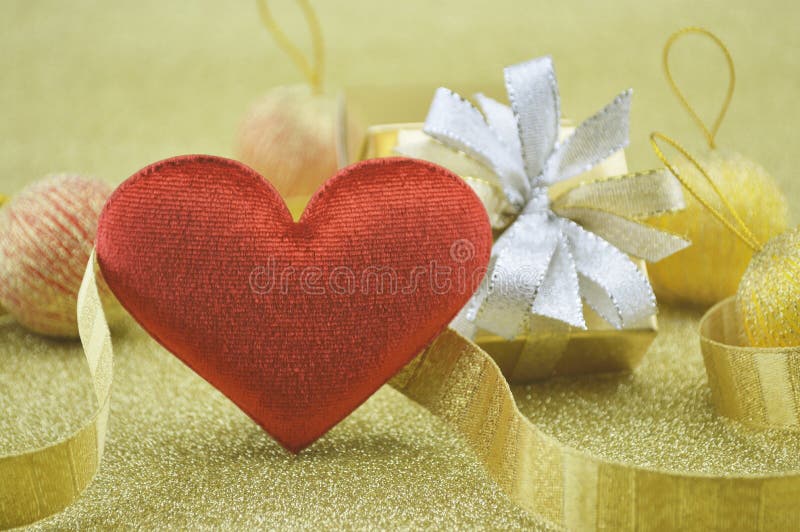 Forma roja del corazón de la tela con la caja de regalo en el fondo del oro, concepto del amor imagen de archivo libre de regalías Forma roja del corazón de la tela con la caja de regalo en el fondo del oro, concepto del amor imagen de archivo libre de regalías